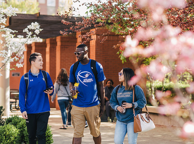 enage-with Three students walking outside to class.